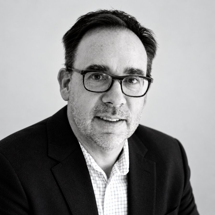 Black-and-white studio portrait of Devon Brown, executive coach and senior facilitator